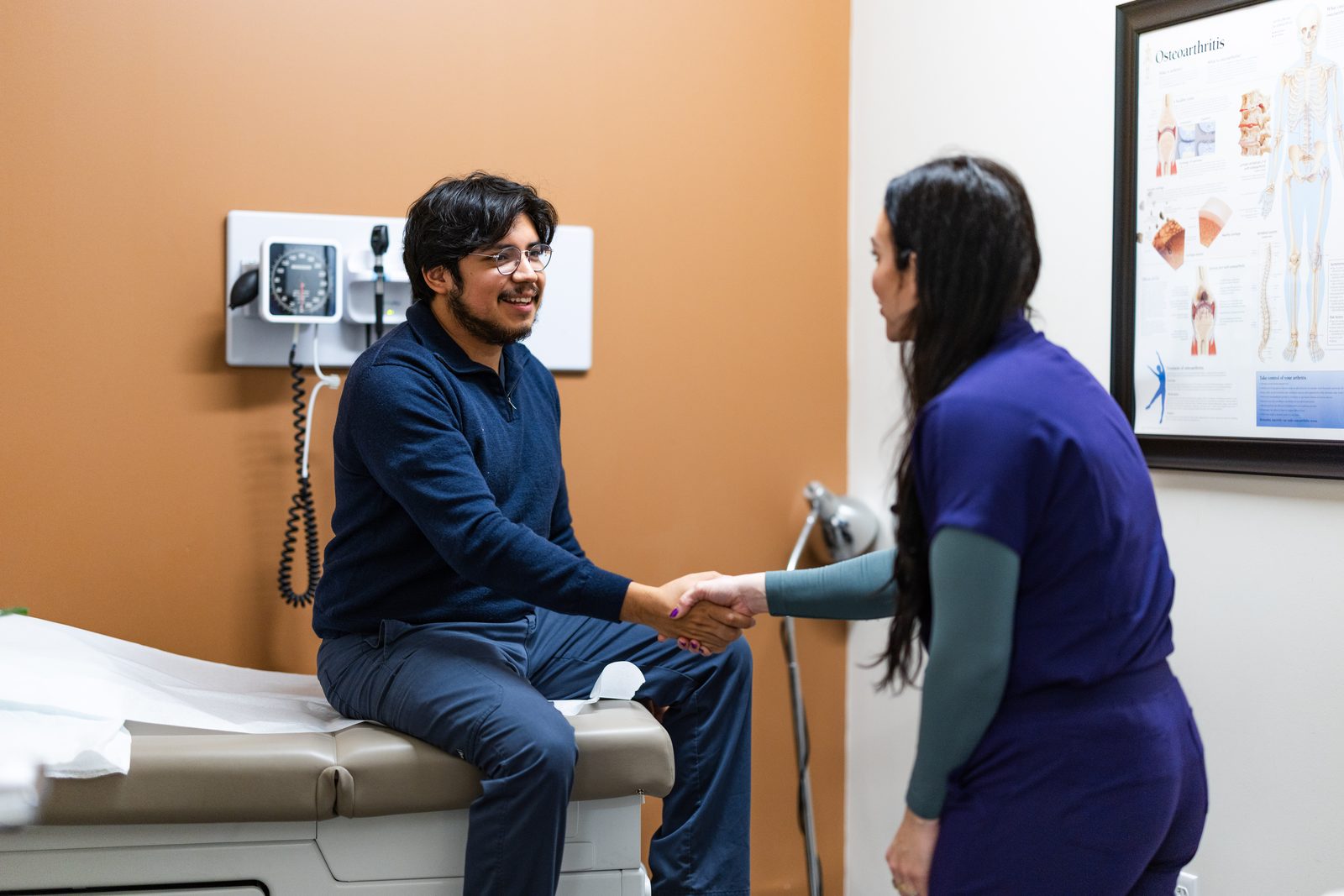 Deedee greeting a patient with a handshake in an exam room at Prime Direct Health in Gilbert